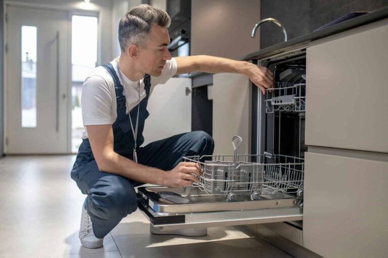 Technician from Quick Repair fixing a dishwasher in Dubai kitchen